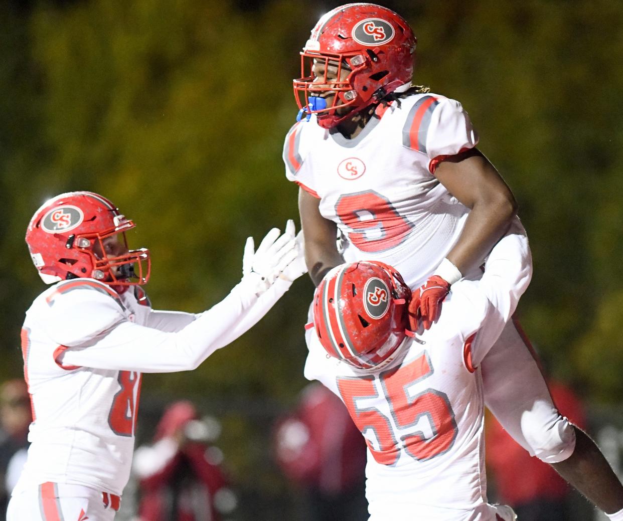 Canton South running back Rome Cox celebrates a second quarter touchdown with Luke Johnson and Joe Meyer at Northwest. Friday, Oct. 20, 2023.