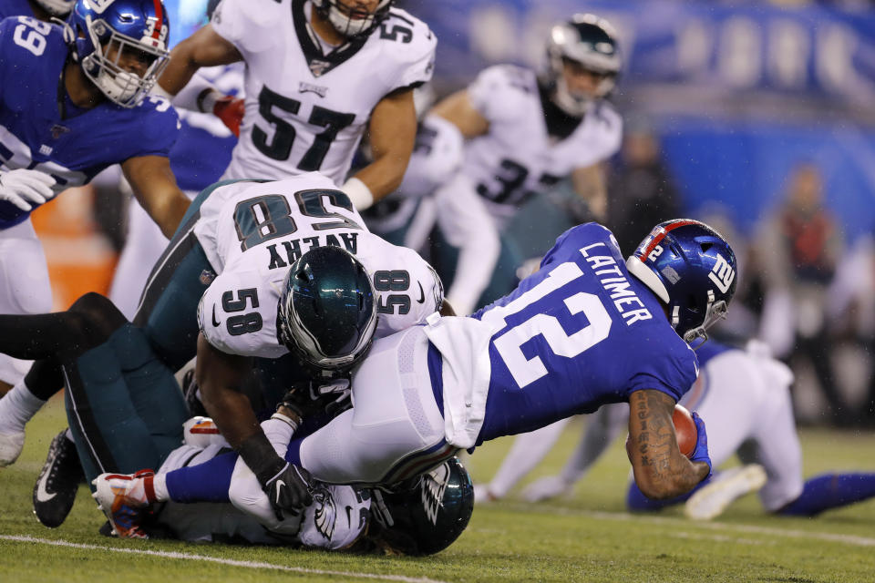 New York Giants wide receiver Cody Latimer (12) is stopped by Philadelphia Eagles defensive end Genard Avery (58) in the first half of an NFL football game, Sunday, Dec. 29, 2019, in East Rutherford, N.J. (AP Photo/Adam Hunger)