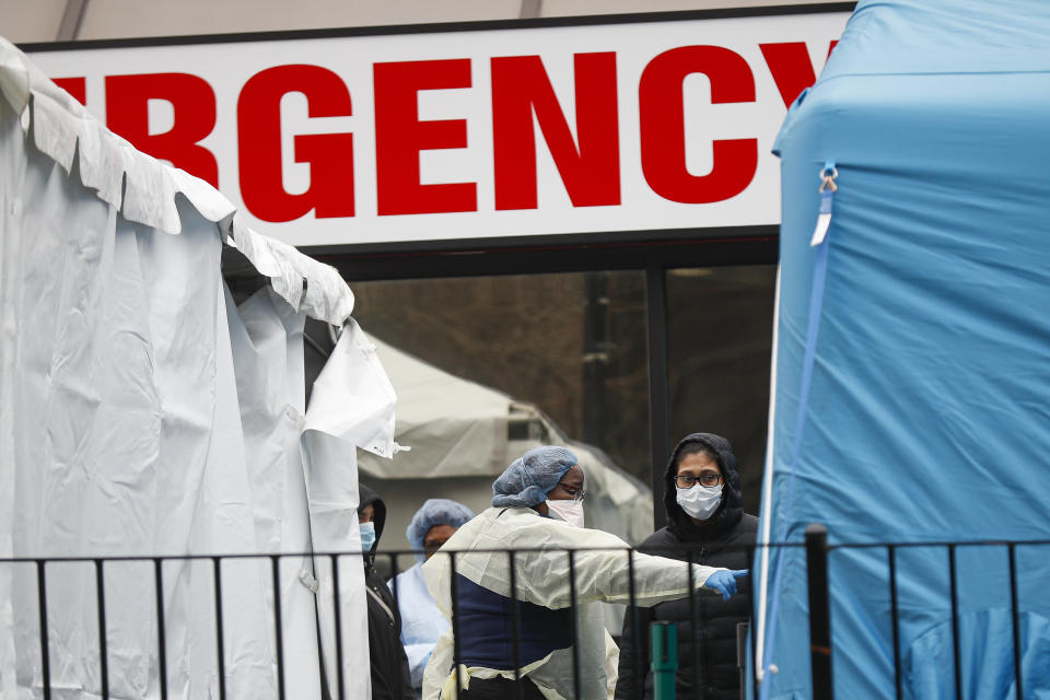 A medical worker directs a patient to enter a COVID-19 testing site at Elmhurst Hospital Center, Wednesday, March 25, 2020, in New York. Gov. Andrew Cuomo sounded his most dire warning yet about the coronavirus pandemic Tuesday, saying the infection rate in New York is accelerating and the state could be as close as two weeks away from a crisis that sees 40,000 people in intensive care. Such a surge would overwhelm hospitals, which now have just 3,000 intensive care unit beds statewide. (AP Photo/John Minchillo)