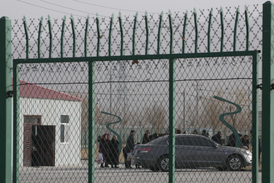 FILE - Residents line up inside the Artux City Vocational Skills Education Training Service Center which has previously been revealed by leaked documents to be a forced indoctrination camp at the Kunshan Industrial Park in Artux in western China's Xinjiang region, Dec. 3, 2018. China has responded furiously to a United Nations report on alleged human rights abuses in its northwestern Xinjiang region targeting Uyghurs and other mainly Muslim ethnic minorities. (AP Photo/Ng Han Guan, File)