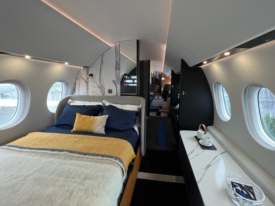 The bedroom on board a Falcon 10X includes a marble table.