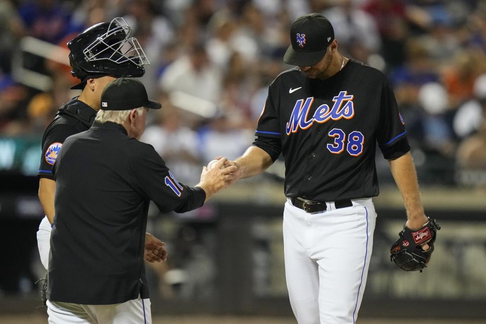 New York Mets starting pitcher Tylor Megill (38) hands the ball to manager Buck Showalter as he leaves during the sixth inning of a baseball game against the Atlanta Braves Friday, Aug. 11, 2023, in New York. (AP Photo/Frank Franklin II)