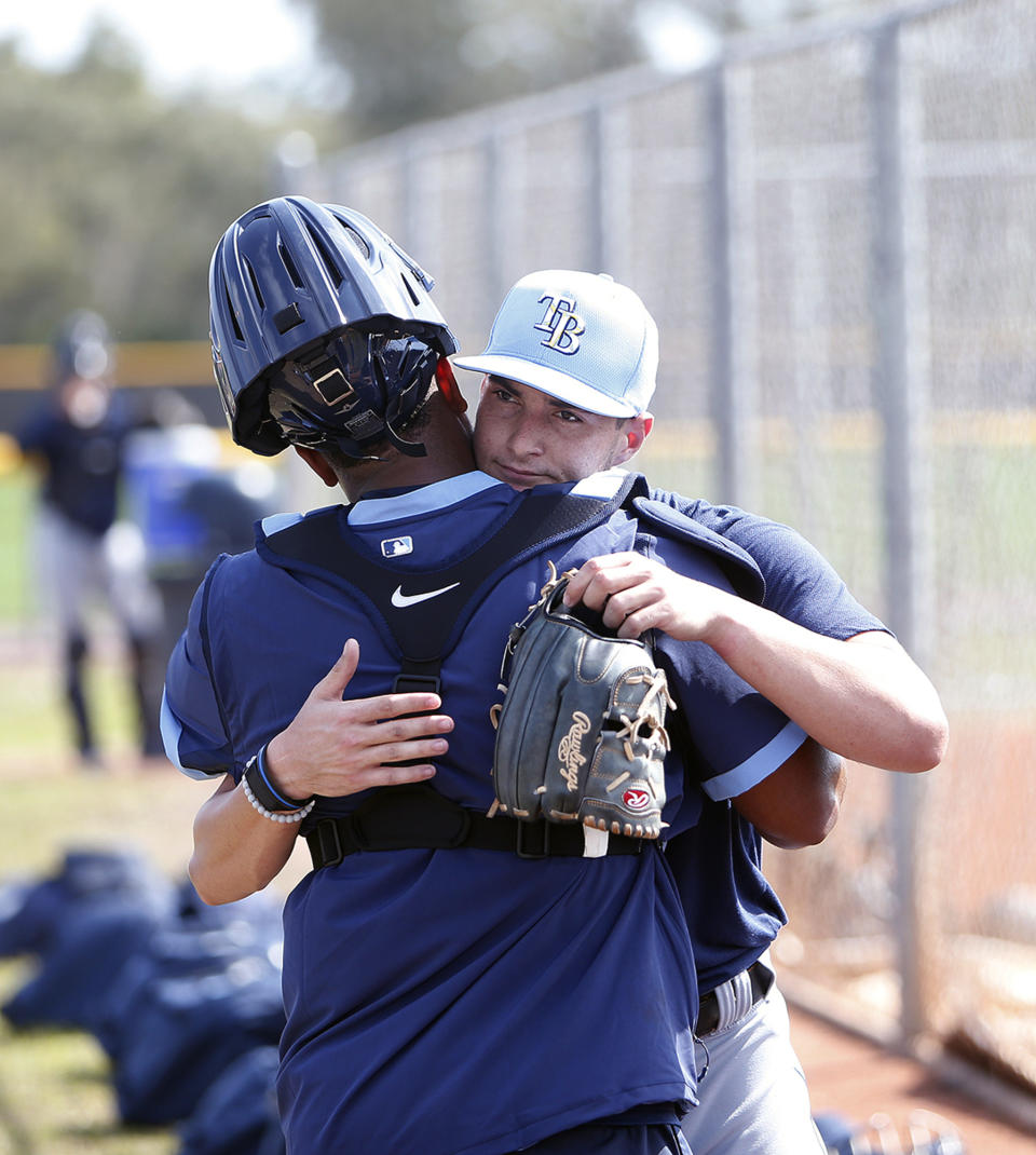 Tampa Bay Rays pitcher Shane McClanahan, right, hugs catcher Ronaldo Hernandez during the start of spring baseball practice Thursday, Feb. 13, 2020 in Port Charlotte, Fla. (Octavio Jones/Tampa Bay Times via AP)