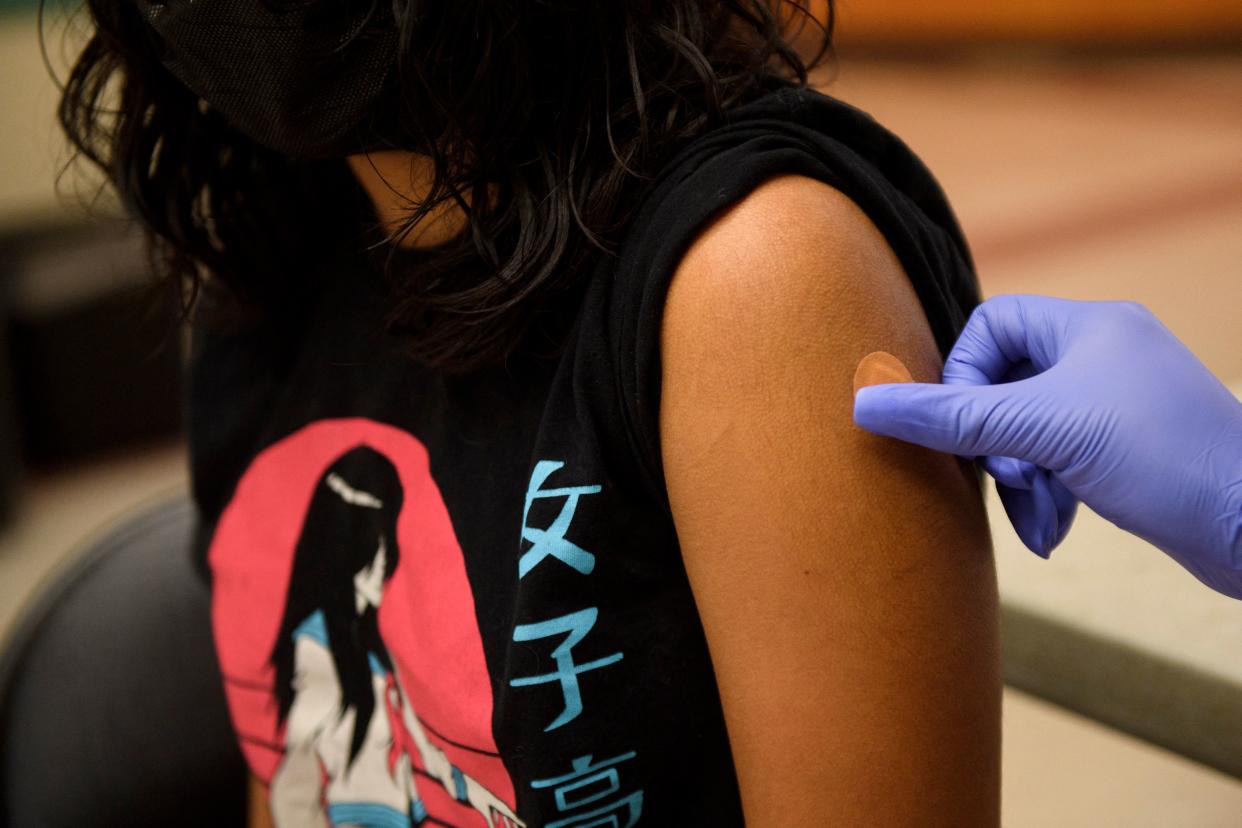 A Band-Aid is placed on the arm of a 12-year-old child after receiving a first dose of the Pfizer COVID-19 vaccine after it was approved for use by the FDA.