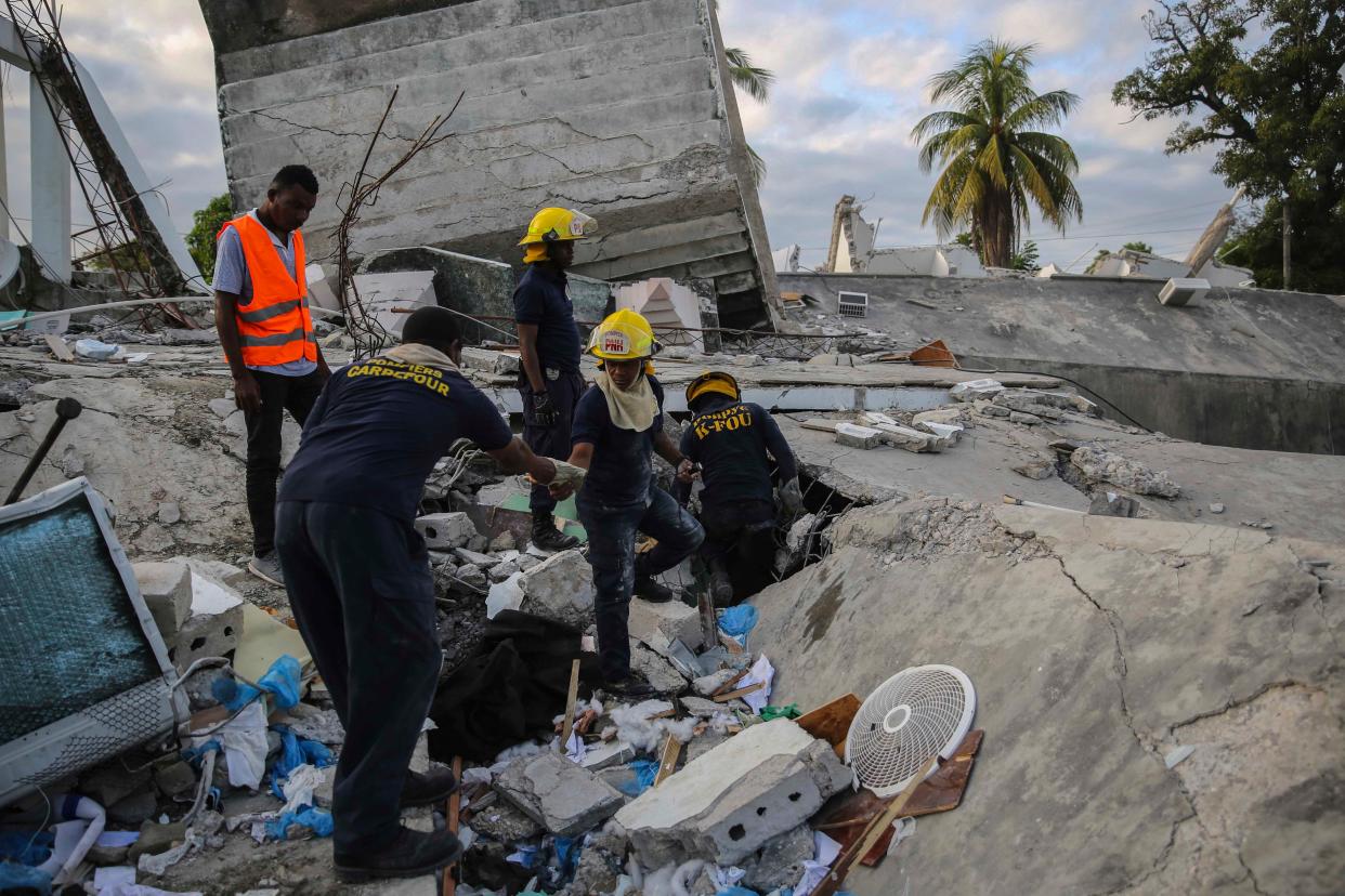 Firefighters search for survivors inside a collapsed building after Saturday's 7.2 magnitude earthquake in Les Cayes, Haiti, Sunday, Aug. 15, 2021.