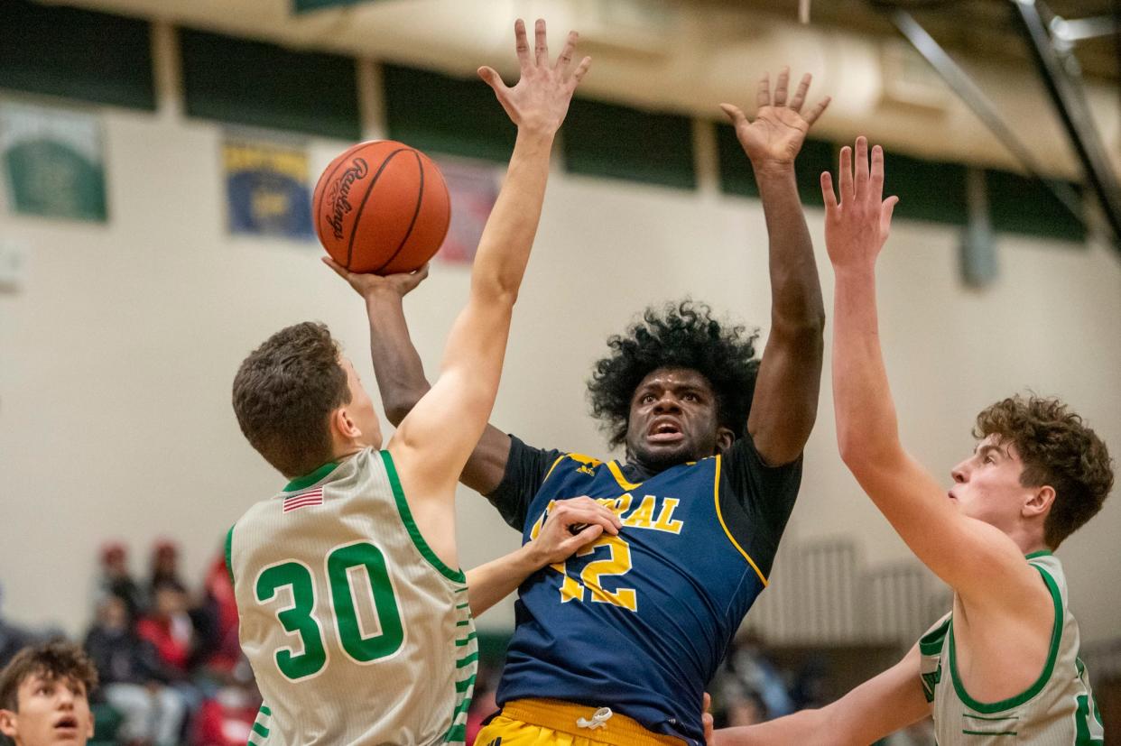 Battle Creek Central senior Kylon Wilson (12) shoots the ball as Pennfield senior Julius Wettschereck (30) guards him at Pennfield High School on Wednesday, Dec. 29, 2021. Pennfield defeated Battle Creek Central 64-60.