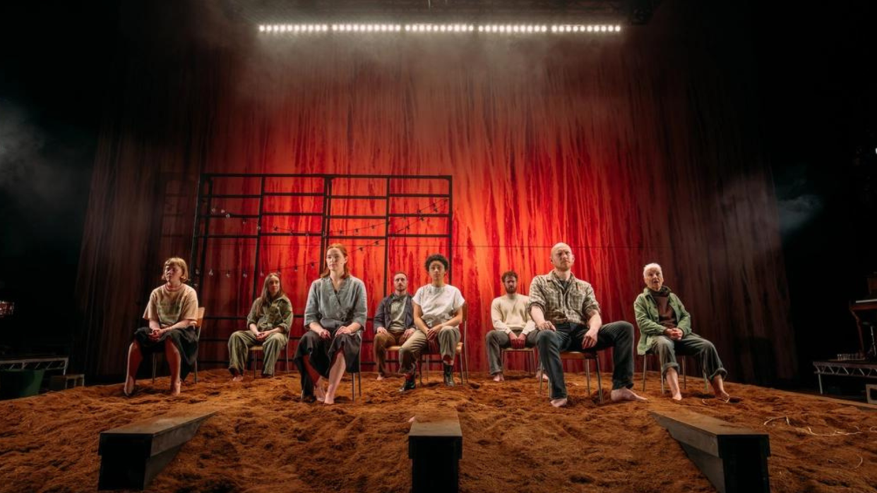  The cast of Sunset Song sit in a row on stage, with Danielle Jam at the front centre. 