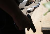 Armed police approach the entrance of Westgate shopping center where a body lays as they hunt gunmen who went on a shooting spree in Nairobi September 21, 2013. (REUTERS/Goran Tomasevic)