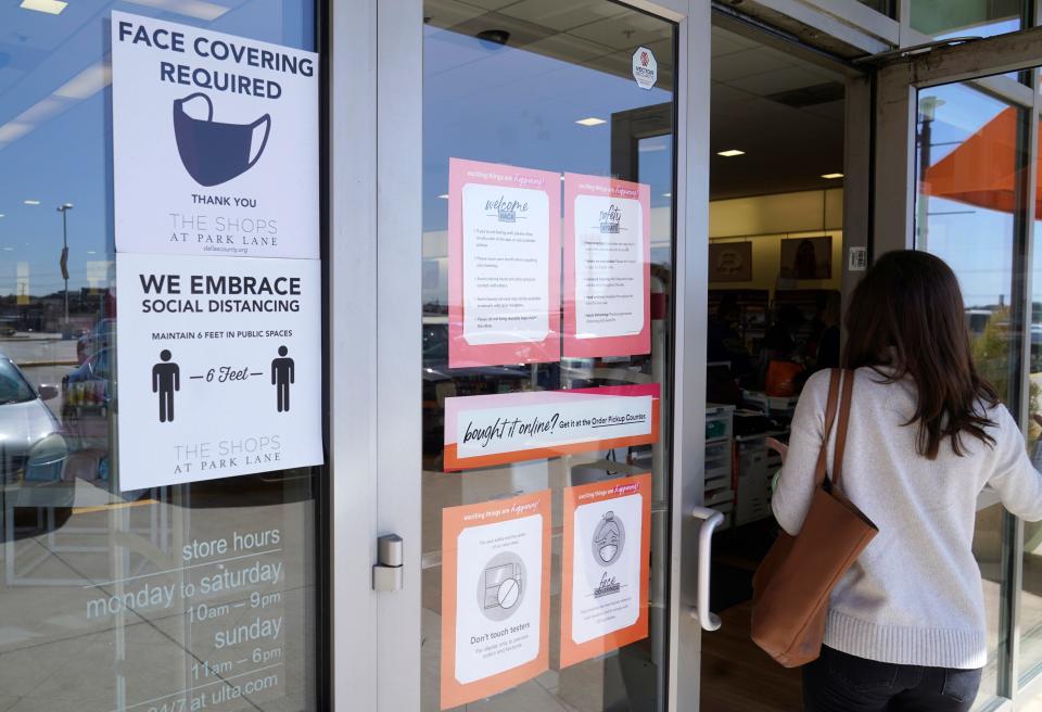 A customer enters a store with a "Face Mask Required" sign in Dallas, in this Tuesday, March 2, 2021, file photo. Although nearly a fifth of U.S. states don't require people to wear masks to protect against COVID-19, some businesses are requiring employees and customers to be masked on their premises. (AP Photo/LM Otero, File)