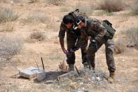 Syrian army soldiers attempt to defuse an IED in northeastern Palmyra on May 17, 2015