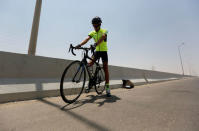 Egyptian cyclist Helmy El Saeed, 27, prepares his bicycle and training equipment on the highway of El Ain El Sokhna, east of Cairo, Egypt July 19, 2017. REUTERS/Amr Abdallah Dalsh