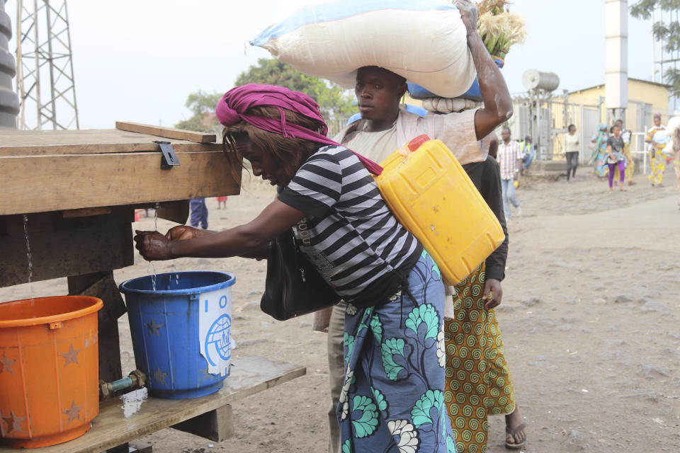 People wash their hands at the Congo side of the Poids Lourd checkpoint at the border between Congo and Rwanda, Thursday, Aug. 1, 2019. Congo's presidency says the border is open again with Rwanda hours after its eastern neighbor closed it over the deadly Ebola outbreak. The closure occurred Thursday morning as the first case of direct transmission of the Ebola virus was confirmed in Goma, the Congo city of more than 2 million people on the Rwandan border.(AP Photo)