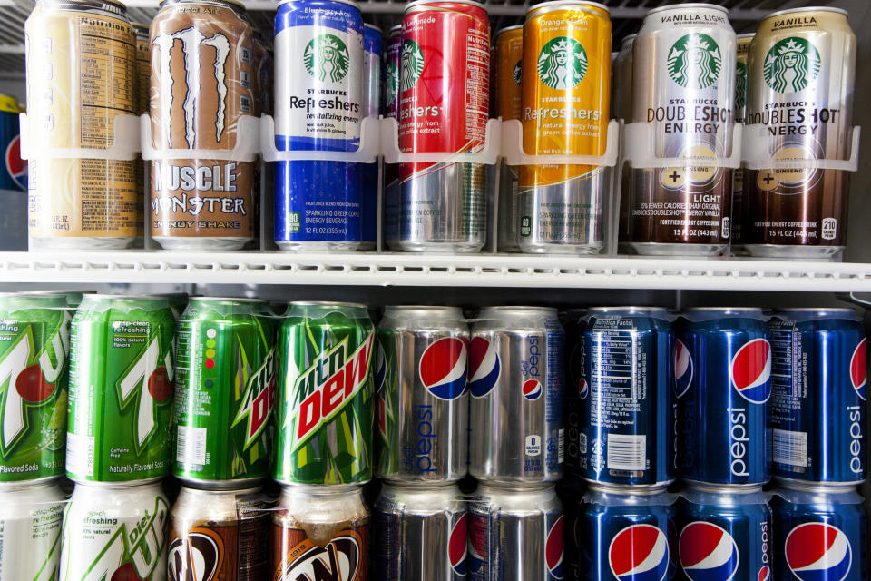 Cans of soda are displayed in a case at Kwik Stops Liquor in San Diego, California February 13, 2014. Sodas and most other sugar-sweetened drinks sold in California would be required to carry warning labels for obesity, diabetes and tooth decay under a bill introduced in Sacramento on Thursday and backed by several public health advocacy groups. REUTERS/Sam Hodgson (UNITED STATES - Tags: POLITICS FOOD HEALTH)