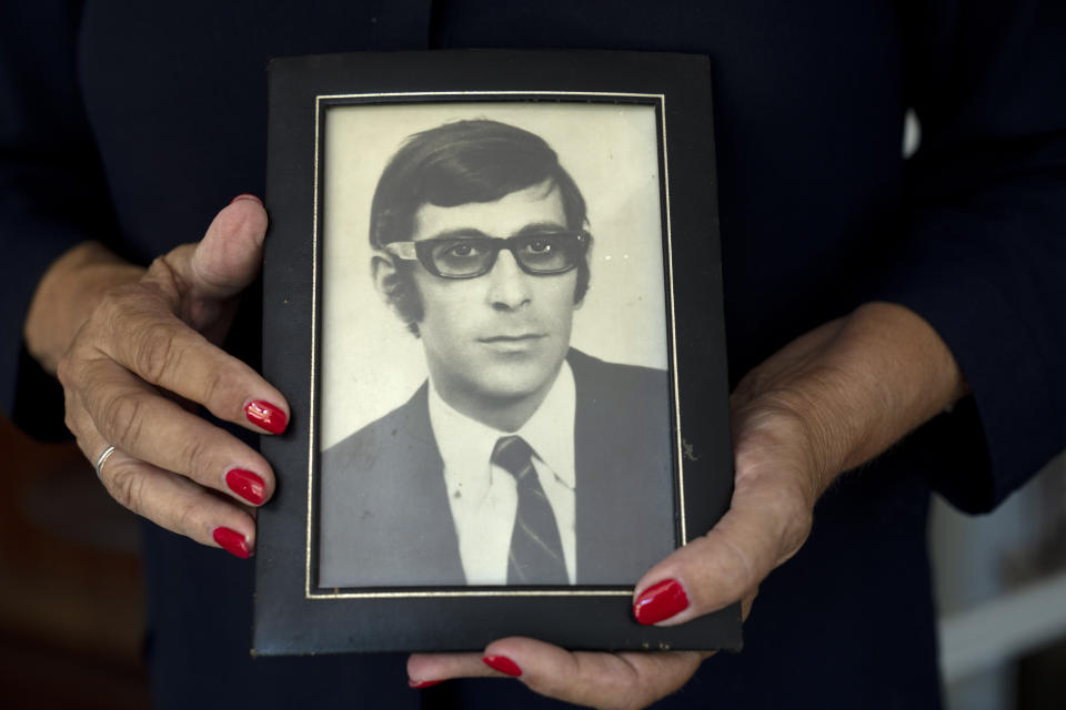 FILE - Ankie Spitzer holds a framed photo her husband Andre had made for the Munich Olympics before his death, as she poses in her home in Ramat Hasharon, Israel, on July 28, 2022. Andre was a fencing coach with the Israeli Olympic team who was killed in the 1972 Summer Olympics in Munich by a Palestinian group. In a decision announced Thursday, Aug. 11, the families of 11 Israeli athletes killed by Palestinian attackers at the Olympics will not attend a 50-year anniversary ceremony organized by German authorities, saying they deserve more compensation and a fuller reckoning of the tragedy. (AP Photo/Maya Alleruzzo, File)