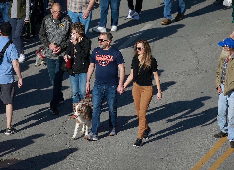 A couple holds hands as they walk along Court Avenue during the opening day of the 2022 downtown Farmers' Market in Des Moines on Saturday, May 7.