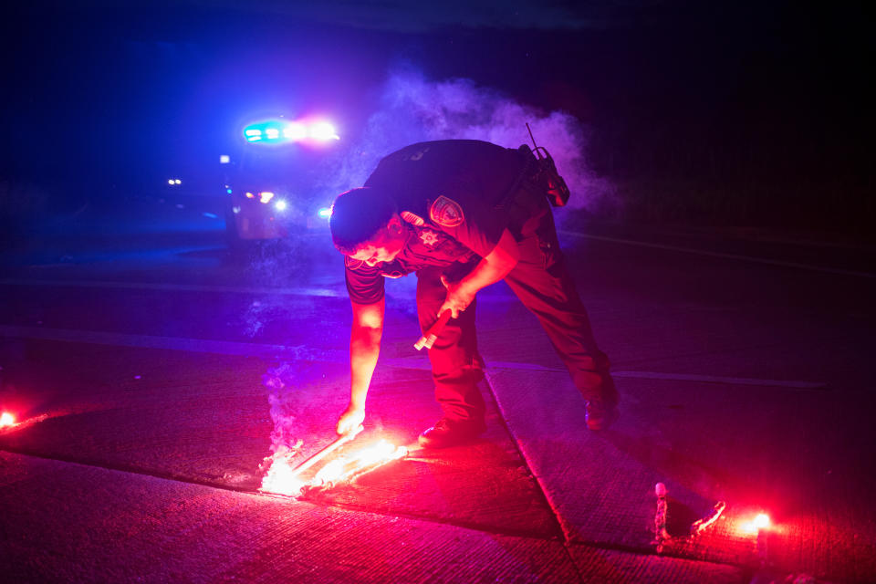 <p>A police officer lays down a safety flare while blocking the road leading to the Arkema SA plant which was hit by floods caused Tropical Storm Harvey near Crosby, Texas, Aug. 31, 2017. (Photo: Adrees Latif/Reuters) </p>