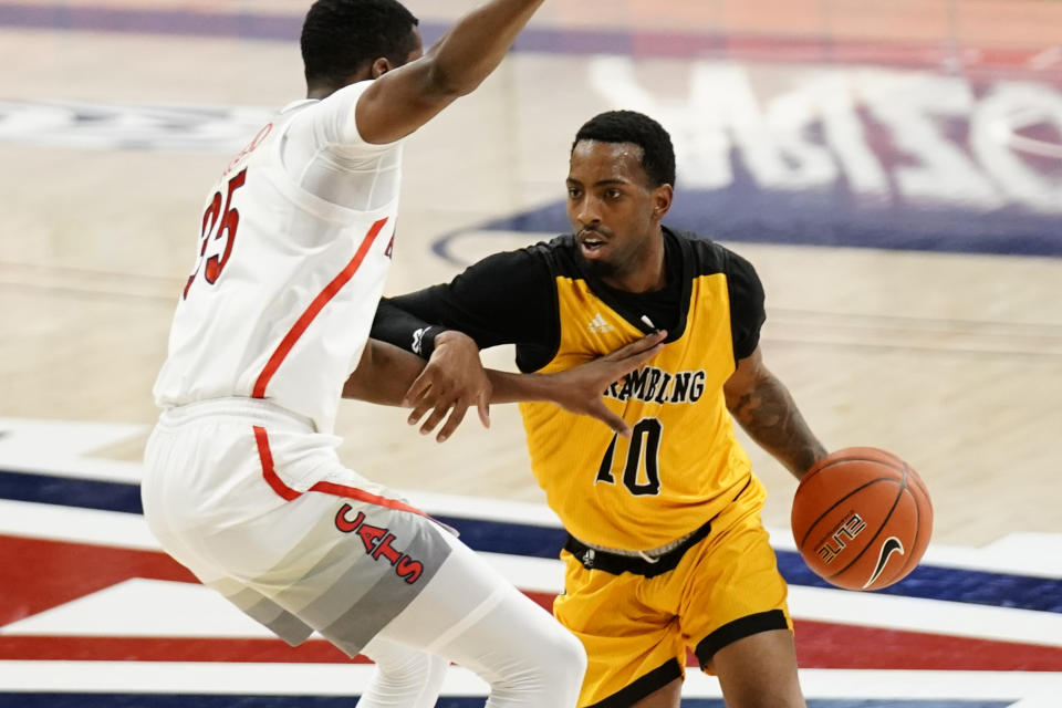 Grambling guard Trevell Cunningham, right, drives against Arizona center Christian Koloko (35) during the first half of an NCAA college basketball game Friday, Nov. 27, 2020, in Tucson, Ariz. (AP Photo/Rick Scuteri)