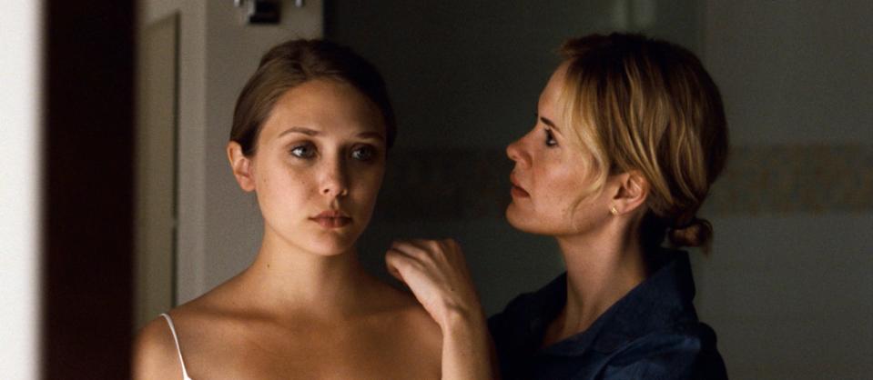 Elizabeth in the film looking in a mirror while another actor fixes her hair