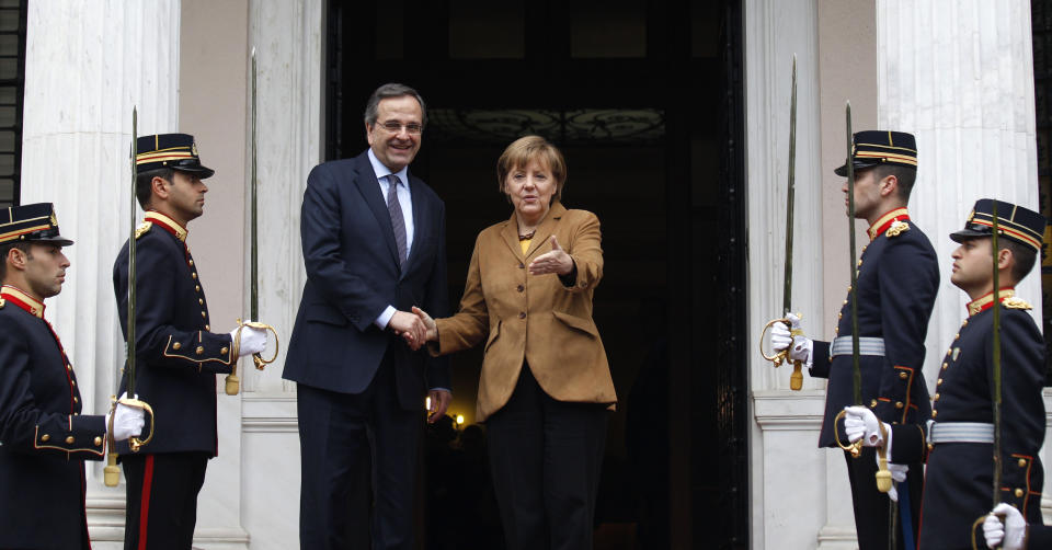 Antonis Samaras, Greece's prime minister, left, greets Angela Merkel, Germany's chancellor, on her arrival at the prime minister's office in Athens, on Friday, April 11, 2014, for a brief visit, a day after the crisis-hit country returned to international bond markets. Greece this week reached a milestone in the recovery from its financial crisis — it successfully tapped bond markets for the first time since 2010, raising 3 billion euros ($4.14 billion) in five-year debt. (AP Photo/Kostas Tsironis/pool)