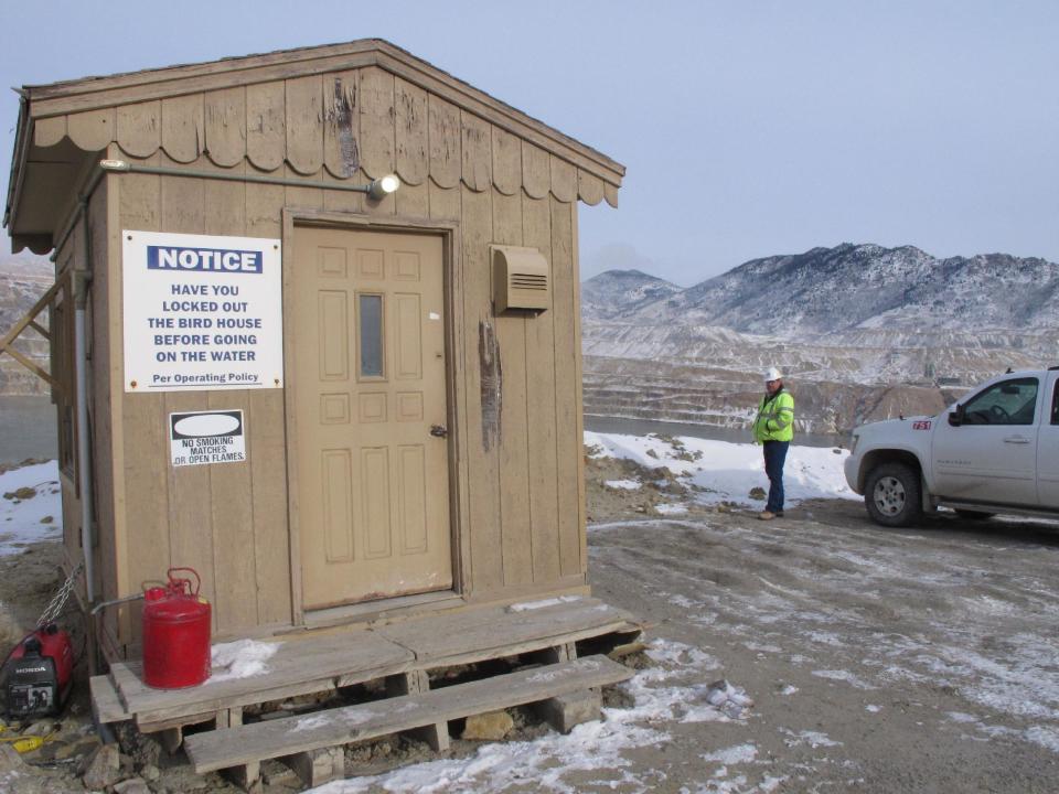 In this Dec. 14, 2016 photo, Montana Resources' Mark Thompson stands on the bank of the Berkeley Pit behind a hut used to watch for birds that try to land in the toxic water in Butte, Mont. Montana Resources is proposing additional technologies such as radars, lasers and drones to prevent another mass death similar to the several thousand snow geese that died in the pit last November. (AP Photo/Matt Volz)