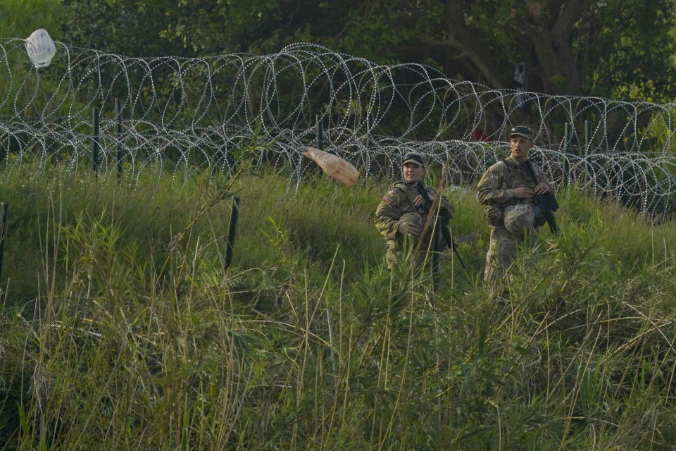 Texas National Guards stand guard on the bank of the Rio Grande river, seen from Matamoros, Mexico, Thursday, May 11, 2023. Pandemic-related U.S. asylum restrictions, known as Title 42, are to expire May 11. (AP Photo/Fernando Llano)