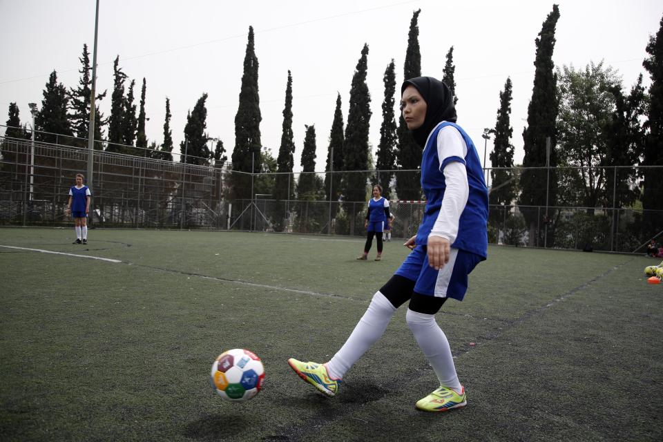 In this Wednesday, April 24, 2019 photo, Fatima from Afghanistan passes the ball during a training session of Hestia FC Women's Refugee Soccer team in Athens. Many of the players at Hestia FC weren't allowed to play or even watch soccer matches in their home countries. Hestia FC was set up by the Olympic Truce Centre, a non-government organization created in 2000 by the International Olympic Committee and Greek Foreign Ministry. (AP Photo/Thanassis Stavrakis)