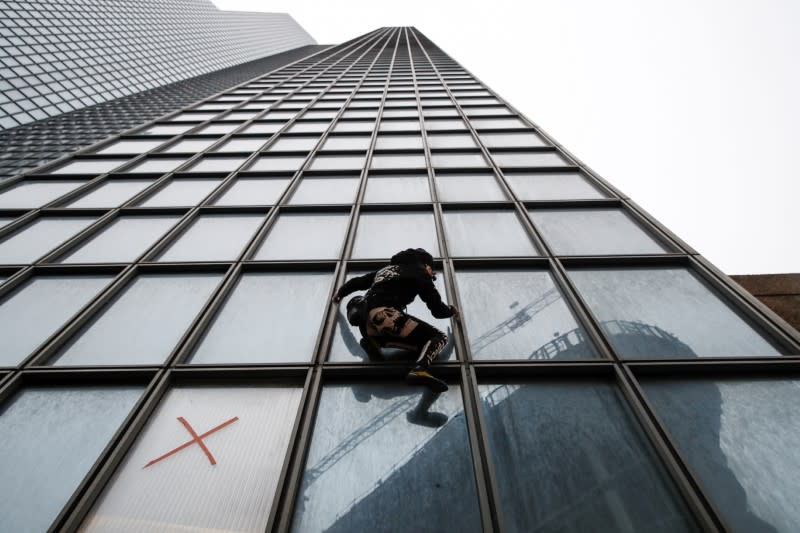 French Spiderman climbs Total tower in support of pensions strikers at La Defense