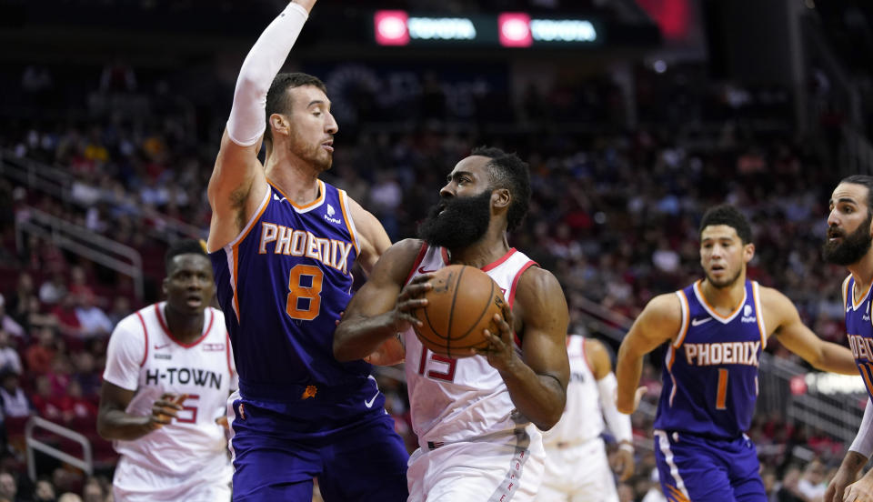 Houston Rockets' James Harden (13) goes up for a shot as Phoenix Suns' Frank Kaminsky (8) defends during the first half of an NBA basketball game Saturday, Dec. 7, 2019, in Houston. (AP Photo/David J. Phillip)