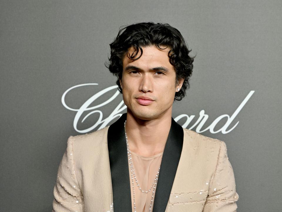 charles melton in a sparkling beige suit on a red carpet