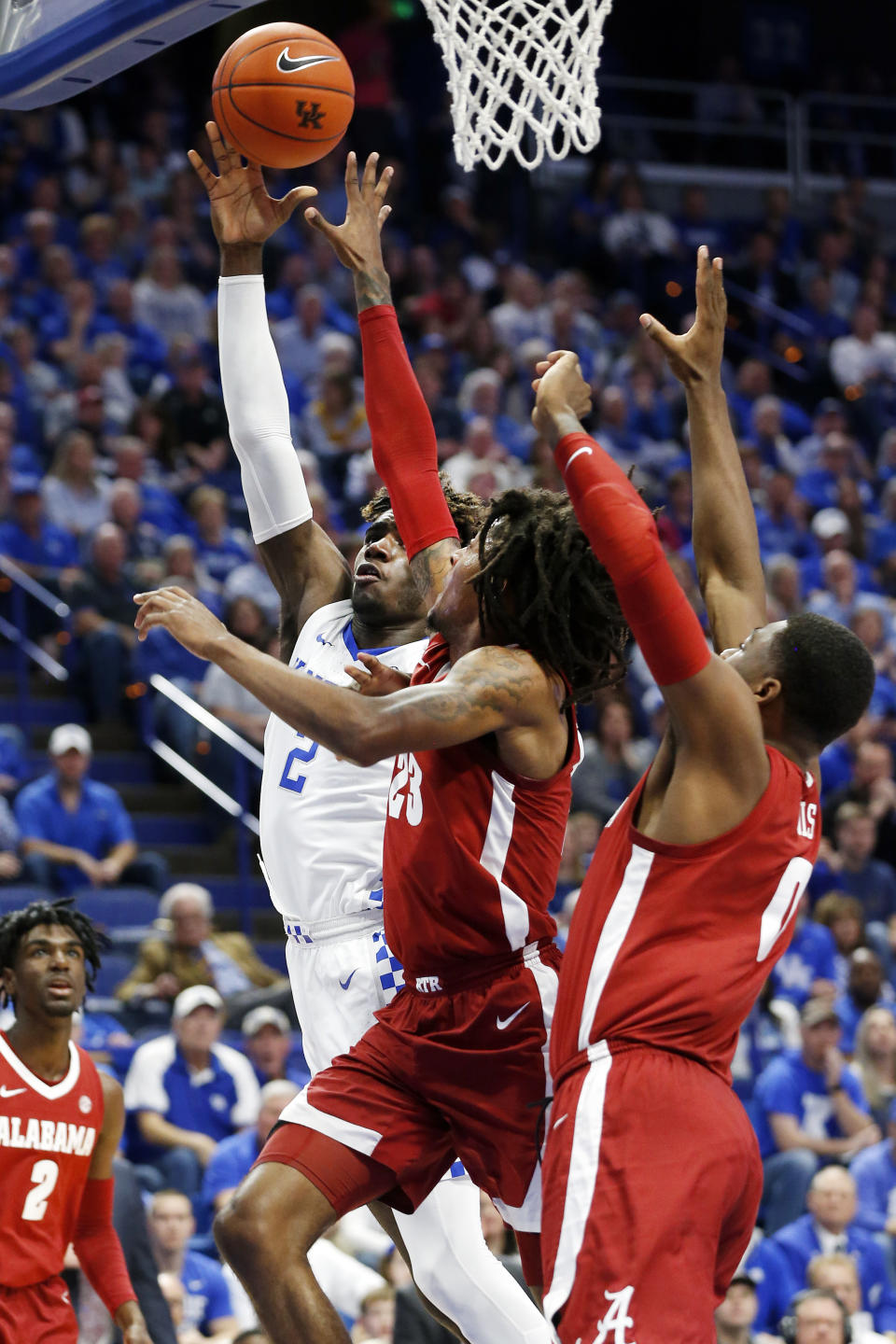 Kentucky's Kahlil Whitney, left, shoots while pressured by Alabama's John Petty Jr. and Javian Davis, right, during the first half of an NCAA college basketball game in Lexington, Ky., Saturday, Jan 11, 2020. (AP Photo/James Crisp)