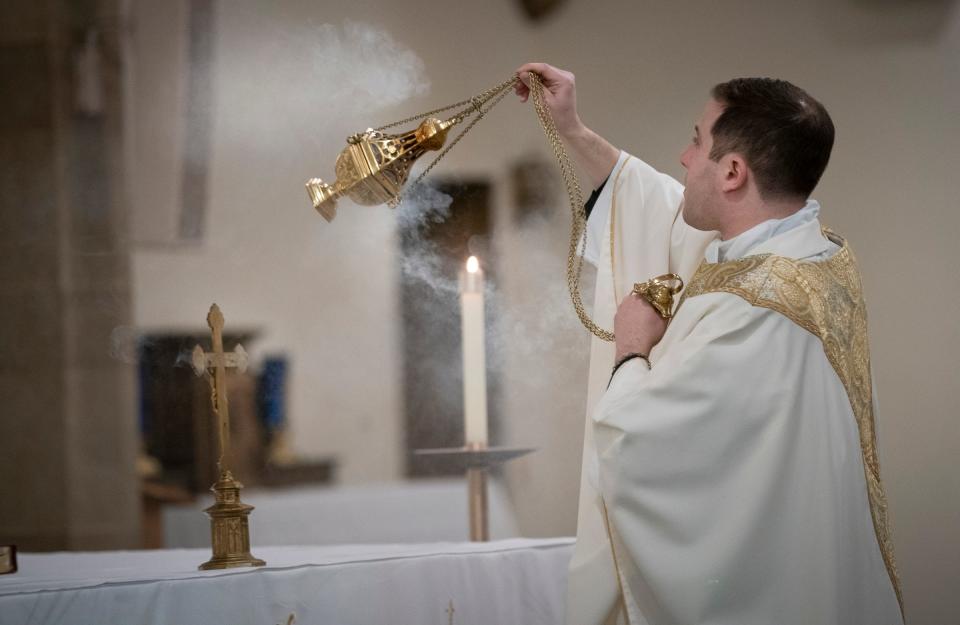 The Rev. Matthew Hood uses a thurible of incense during Holy Thursday services Thursday, April 6, 2023, at Our Lady of the Rosary Catholic Church in Detroit.
