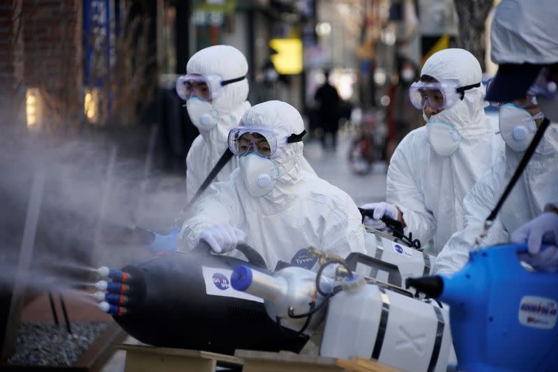 Employees from a disinfection service company sanitize a shopping district in Seoul