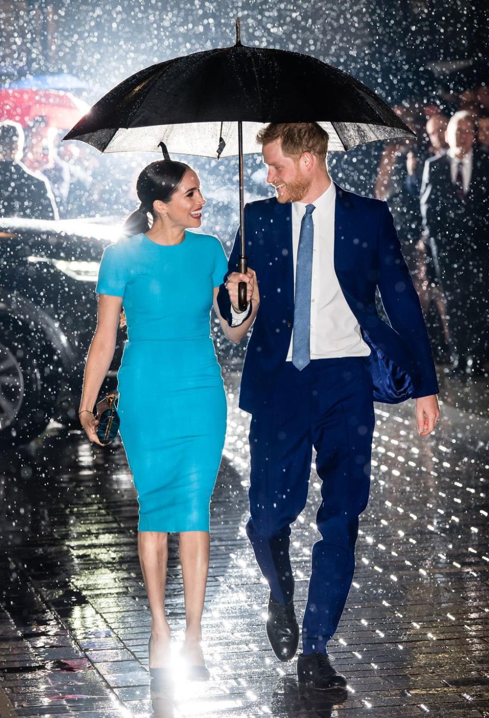 <p>The couple were photographed smiling at each other in the rain as Prince Harry held an umbrella over his wife's head. Could this be any sweeter? </p>