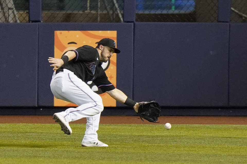 Miami Marlins right fielder Adam Duvall chases down a ball hit by Atlanta Braves' Ozzie Albies that scored Ronald Acuna Jr. during the first inning of a baseball game, Friday, June 11, 2021, in Miami. (AP Photo/Wilfredo Lee)