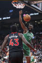 Boston Celtics' Jaylen Brown, right, scores as Toronto Raptors' Pascal Siakam looks on during the first half of an NBA basketball game in Toronto, Sunday, Nov. 28, 2021. (Chris Young/The Canadian Press via AP)