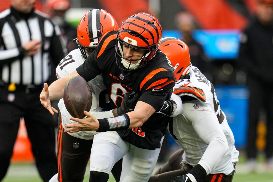 Cincinnati Bengals quarterback Jake Browning (6) recovers his own fumble as he's sacked by Cleveland Browns defensive end Alex Wright (91) and defensive end Isaiah McGuire (57) in the second half Sunday in Cincinnati.