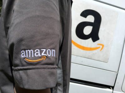 FILE PHOTO: An Amazon.com Inc driver stands next to an Amazon delivery truck in Los Angeles, California, U.S., May 21, 2016. REUTERS/Lucy Nicholson/File Photo