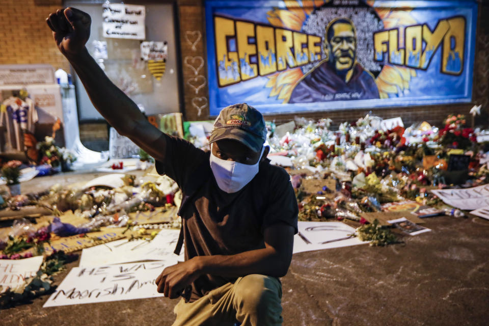 FILE - In this Monday, June 1, 2020 file photo, protesters gather at a memorial for George Floyd where he died outside Cup Foods on East 38th Street and Chicago Avenue in Minneapolis. Floyd died after being restrained by Minneapolis police officers on May 25. The deaths of Floyd and other black men at the hands of Minneapolis police have exacerbated the corrosive relationship between people of color and a criminal justice system they feel is stacked against them. (AP Photo/John Minchillo)