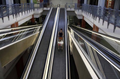 A woman stands on an escalator with her shopping trolley at a partially empty shopping mall in Nicosia on June 21. In lodging its request for rescue cash Cyprus did not specify how much it needed or whether the help was for its banks or a general government bailout