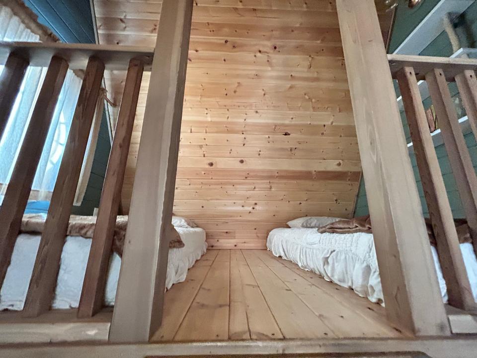 entrance to upper area with two beds, wood ceilings