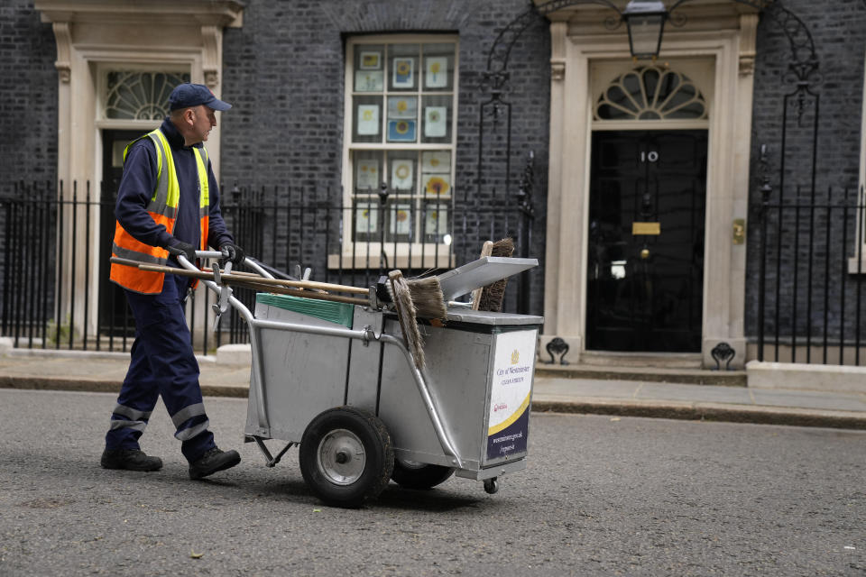 A street cleaner walks past 10 Downing Street, in London, Wednesday, May 25, 2022. British Prime Minister Johnson is awaiting a senior civil servant's report into lockdown-breaking government parties that could further weaken his grip on power. The results of senior civil servant Sue Gray's investigation of the "partygate" scandal could come as soon as Wednesday, and will pile more pressure on the prime minister. (AP Photo/Matt Dunham)