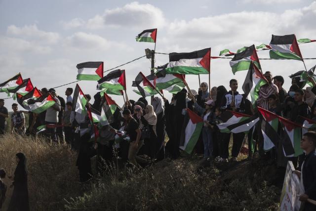 Palestinians in Gaza wave their national flag during a protest against an Israeli march through Jerusalem’s Old City on May 18, 2023. (AP Photo/Fatima Shbair)