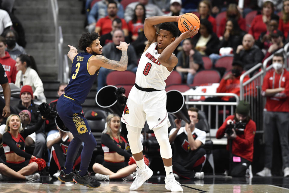 Louisville guard Noah Locke (0) passes the ball away from Notre Dame guard Prentiss Hubb (3) during the first half of an NCAA college basketball game in Louisville, Ky., Saturday, Jan. 22, 2022. (AP Photo/Timothy D. Easley)