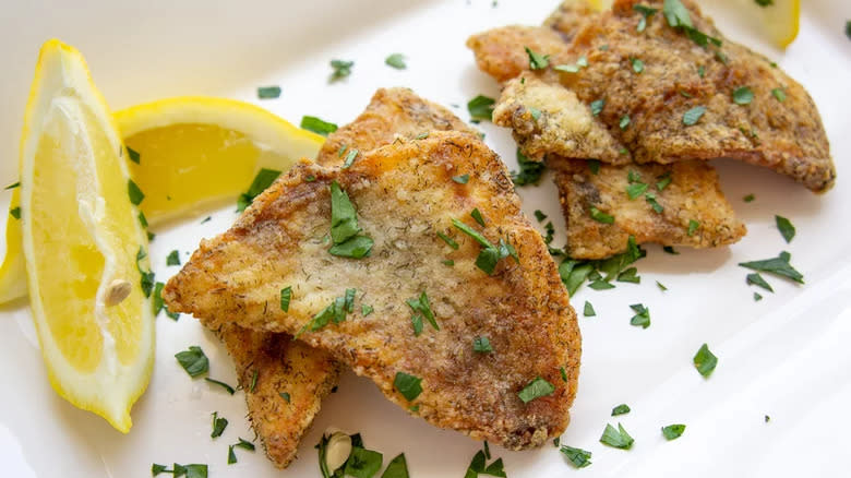 Fried fish with lemon wedges
