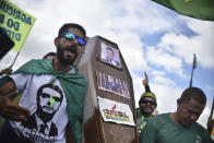 Supporters of Brazil's President Jair Bolsonaro carry a coffin with the image of former Justice Minister Sergio Moro during a protest against the Supreme Court and Brazil's National Congress, and to back Bolsonaro's open-the-economy drive amid the pandemic, in Brasilia, Brazil, Sunday, May 17, 2020. Bolsonaro greeted hundreds of supporters who gathered at the presidential residence to back his open-the-economy drive even as the COVID-19 pandemic sweeps across the country. (AP Photo/Andre Borges)