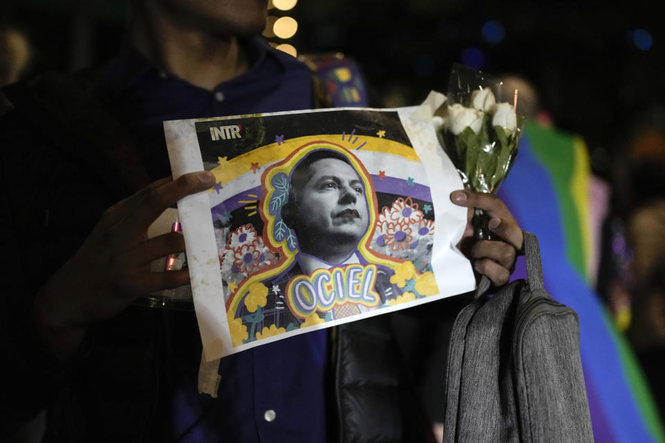 Un manifestante sostiene una fotografía del magistrade del Tribunal Electoral del estado de Aguascalientes Jesús Ociel Baena durante una vigilia tras su muerte, en la Ciudad de México, el 13 de noviembre de 2023. (AP Foto/Eduardo Verdugo)