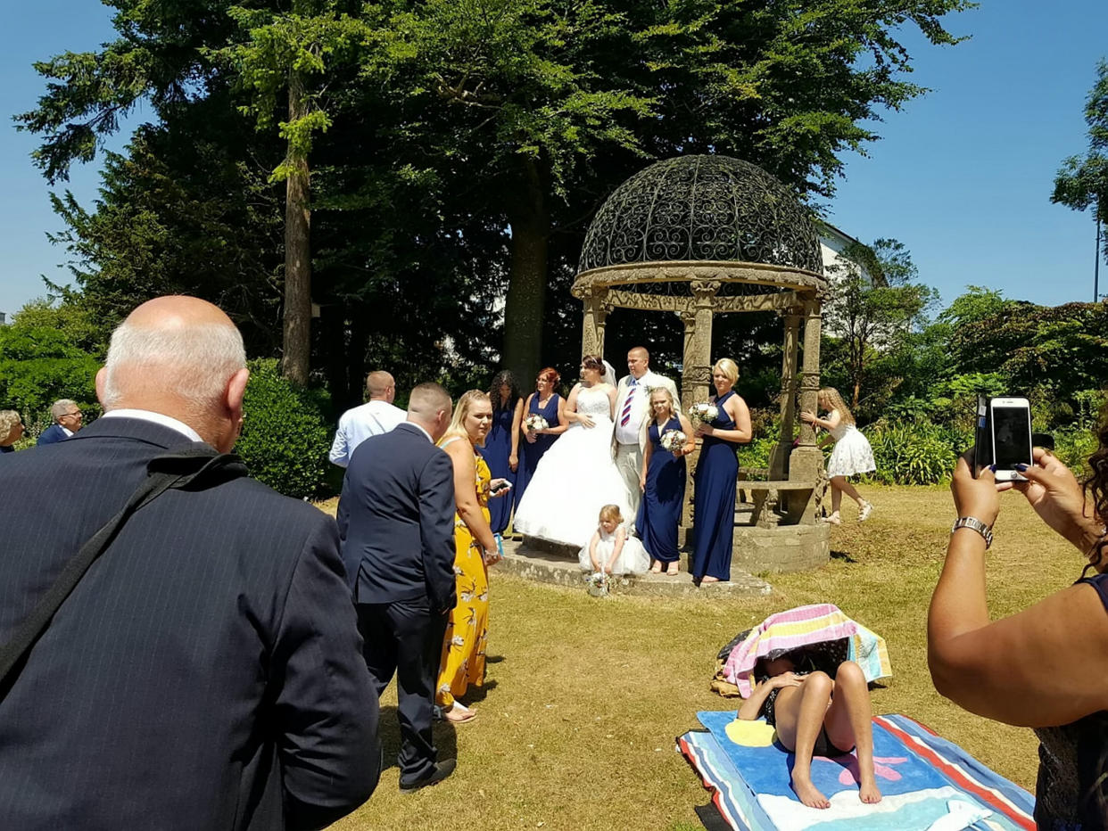 <em>Photobomb – Mark Ling and Mandy Cripwell say the stubborn sunbather refused to move as they tried to have their wedding pictures taken (Picture: SWNS)</em>