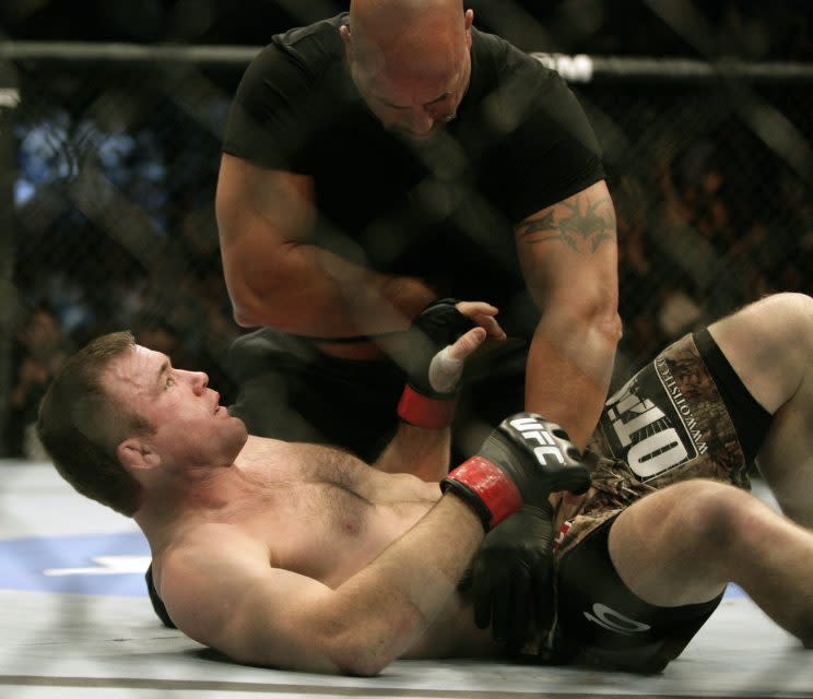 Referee Dan Miragliotta tends to Matt Hughes after Hughes was knocked out in 21 seconds by B.J. Penn at UFC 123 on Sept. 20, 2010. (The Associated Press)