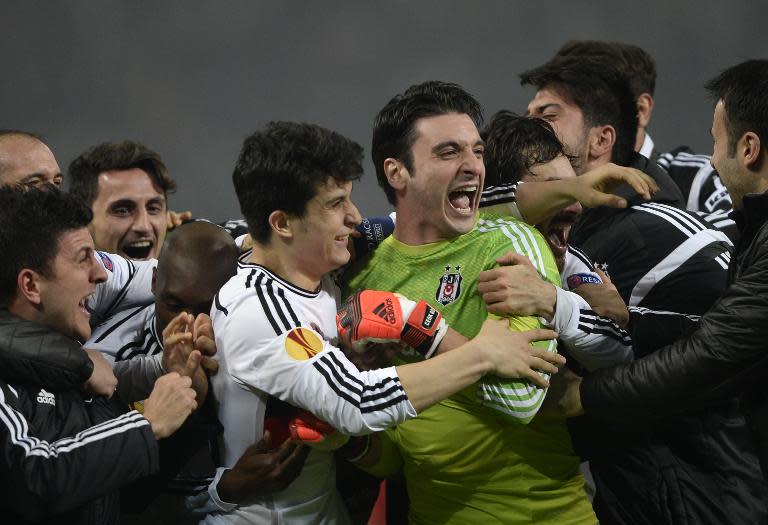 Besiktas players celebrate after defeating Liverpool in the Europa League round of 32 second-leg match in Istanbul on February 26, 2015