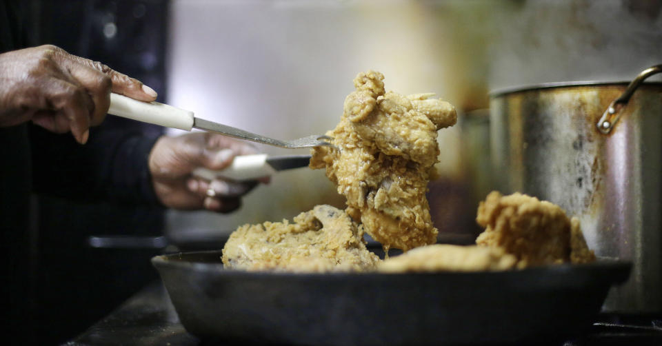 In this Friday, March 22, 2013 photo, Bolton Matthews fries chicken at Bolton's Spicy Chicken and Fish restaurant in Nashville, Tenn. Hot chicken -- fried chicken with varied amounts of seasoning that make the heat level run from mild to extra hot -- is a signature dish of Nashville. (AP Photo/Mark Humphrey)